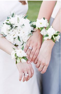 the bride and groom are holding hands with their wedding bouquets on their wristes