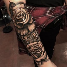 a woman's arm with roses and a wolf tattoo on her left arm, in black and white