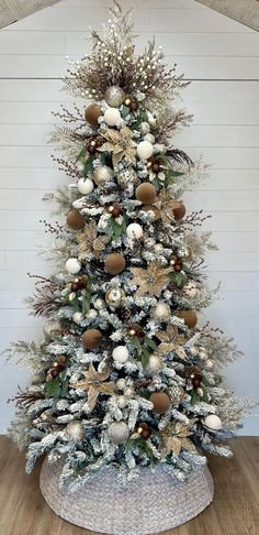 a white christmas tree with gold and silver ornaments