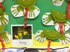 some green and white paper cutouts with red ribbon around them on a bulletin board