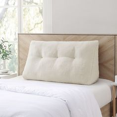 a bed with a white pillow on top of it