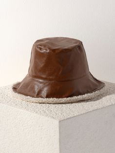 Who says bucket hats are just for summer? Stay warm, stay stylish with Shiraleah's Marta Bucket Hat. This updated bucket hat features a durable PU exterior in a stylish brown color with an interior lining of plush and trendy sherpa fabric that is sure to take your winter look up a notch. Luxurious sherpa lining ensures your warmth while the chic exterior makes it stand out from other boring winter hats. Pair with other cold weather accessories from Shiraleah to complete your look! Shiraleah is a Spa Wraps, Sherpa Fabric, Accessories Display, Cold Weather Accessories, Framed Gifts, Bucket Hats, Sherpa Lined, Frame Decor, Winter Looks