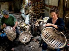 two women are working on baskets made out of wood