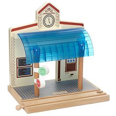 a toy model of a small building with a clock on the front and blue awning