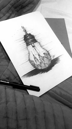 a black and white photo of a drawing on a bed with a pen next to it