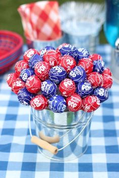 a bucket filled with chocolate candies on top of a blue and white checkered table cloth