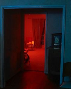 an open door leading to a bedroom with red light coming in from the closet area