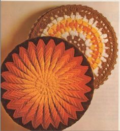 two crocheted baskets sitting next to each other