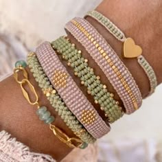 a woman's arm wearing bracelets with gold hearts and beads on the wrist