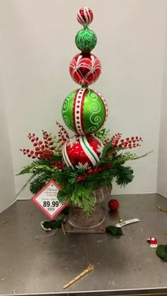 a christmas tree made out of balls and ornaments in a pot on top of a table