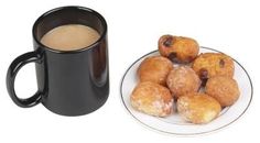 a plate of donuts next to a cup of coffee