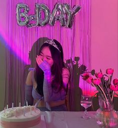 a woman sitting at a table in front of a cake