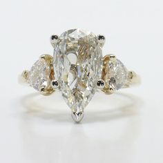 an oval cut diamond ring with three pear shaped diamonds