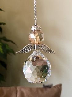 a glass angel ornament hanging from a chain