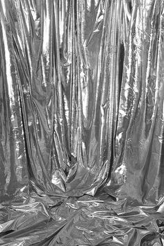 a black and white photo of some metallic foil covering the walls in an area that looks like it is being used as a backdrop