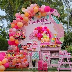 there is a pink flamingo themed birthday party with balloons and decorations on the table