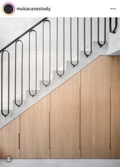 a man riding a skateboard down the side of a wooden stair case next to a hand rail