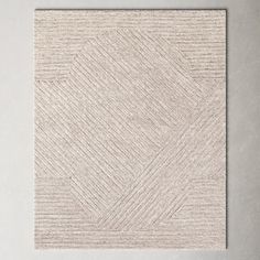 a white square rug on top of a wooden floor