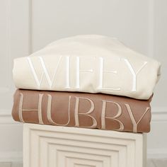 two pillows stacked on top of each other with the words wife and hubby printed on them