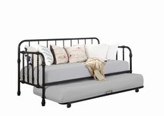 a metal daybed with lots of pillows and blankets on it's back end