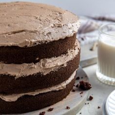 a chocolate cake sitting on top of a white plate next to a glass of milk