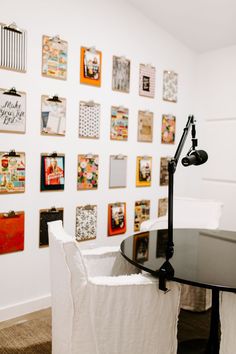 a black table with a microphone on it in front of a wall full of pictures