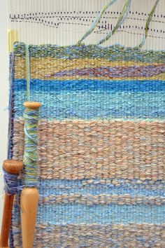 a close up of a weaving machine with yarn on it and a wooden spool