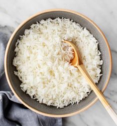 white rice in a bowl with a wooden spoon and napkin on the side, ready to be eaten