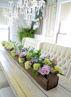 a dining room table with flowers and chandelier hanging from the ceiling