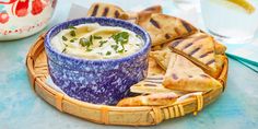 a bowl of hummus and pita chips on a plate