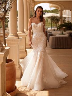 a woman in a wedding dress is standing on the porch with her hand on her hip