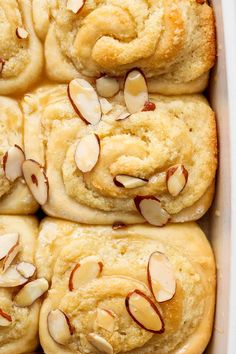 rolls with almonds in a white baking dish