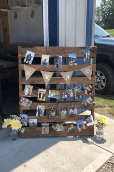 a wooden pallet with pictures on it and flowers in vases next to it