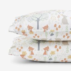 two pillows with foxes and trees on them