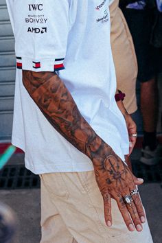 a man with tattoos on his arm and hand