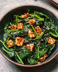 a bowl filled with green vegetables and tofu