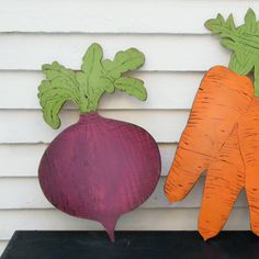 two wooden carrots and a radish on a shelf