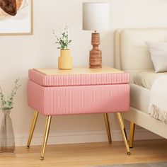 a bedroom with a bed, nightstand and pink trunk on the end table in front of it