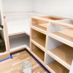 a paint can is sitting on the floor next to shelves