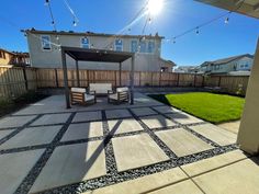 an outdoor patio with chairs and string lights on the side of the fenced in area