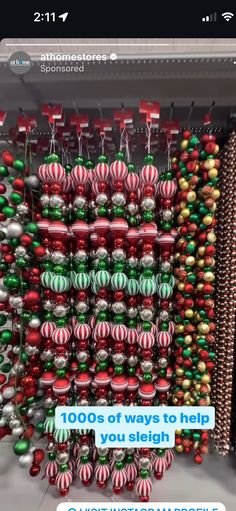 a bunch of christmas ornaments hanging from the ceiling in front of a wall with text that reads