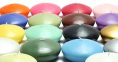 many different colored candles are lined up in the shape of an egg on a white background