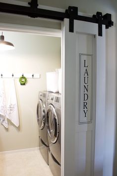 an open door leading to a washer and dryer in a room with white walls