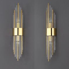 two wall sconces with gold and clear glass rods on the sides, one in front of the other