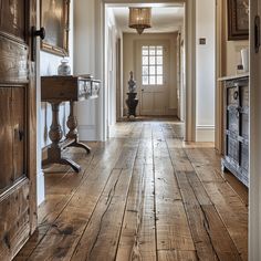 An English countryside hallway with rich, warm hardwood floorboards, showcasing the natural grain and character of the wood4 English Countryside House Interior, Countryside House Interior, English Countryside House, Kitchen Extension Open Plan, Cottage Foyer, English Countryside Aesthetic, Cozy Entryway, English Countryside Home, Classic Entrance