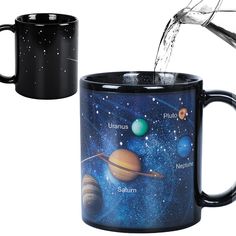 two black mugs with planets on them and water pouring from one cup into the other