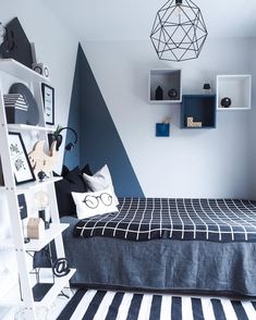 a bedroom with blue and white decor on the walls, striped flooring and a black and white bed