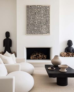 a modern living room with white furniture and art on the wall