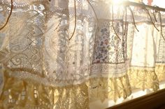 the sun shines brightly through lace curtains