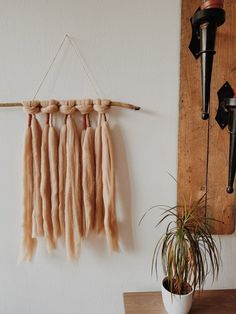 the wall hanging is made out of wood and has long, brown hair on it